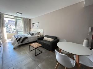 a living room with a bed a table and a couch at Marais Recoleta in Buenos Aires