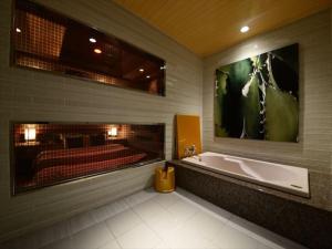 ein Badezimmer mit Badewanne und ein großes Wandgemälde in der Unterkunft HOTEL CHANT - Adult Only 大人専用 in Sakai