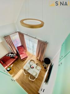 uma vista para uma sala de estar com uma mesa em SINAI APH Apartments em Sinaia