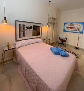um quarto com uma cama grande e um edredão rosa em La Macarena em Sevilha