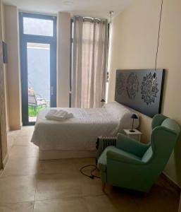 um quarto com uma cama, um sofá e uma cadeira em La Macarena em Sevilha