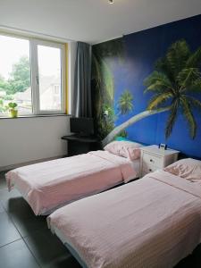two beds in a room with a palm tree mural at Rooms for longer stays with Invoice in Houten