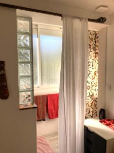 ラ・シオタにあるCozy room on the beachの窓とカーテン付きのベッドルーム1室