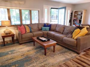 Sala de estar con sofá marrón y mesa de centro en Hidden Oasis Close to Beach and Town, en South Haven