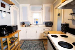 a kitchen with white cabinets and a white stove top oven at Seafare in Seaside