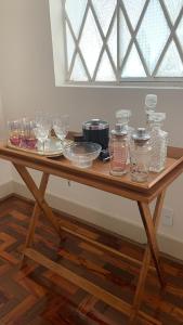 una mesa de madera con tazones y vasos. en Hospedaria das Brotas, en Espírito Santo do Pinhal