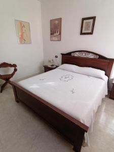 - une chambre avec un grand lit et une chaise dans l'établissement Lemon House, à Sassari