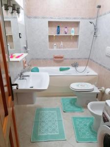 La salle de bains est pourvue d'un lavabo, d'une baignoire et de toilettes. dans l'établissement Lemon House, à Sassari