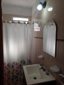 ein Bad mit einem Waschbecken und einem Duschvorhang in der Unterkunft Depto Cuca y Andrés in Cerro de Oro