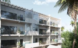 an apartment building with balconies and palm trees at Bunah Tulum -Distinctive Hotels- in Tulum