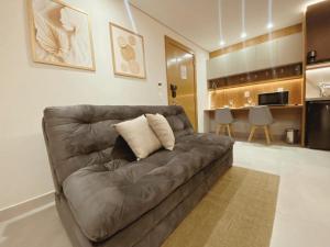 een bruine bank in een woonkamer met een keuken bij Flat Île de Pipa Luxxor - By Almare in Pipa