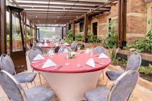 a red table and chairs in a room with a table at Hotel 101 Park House in Bogotá