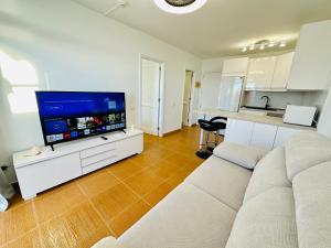 a living room with a couch and a flat screen tv at AMADORES BEACH VIEW APARTMENT in Amadores