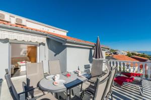 eine Terrasse mit einem Tisch und Stühlen auf dem Balkon in der Unterkunft Apartment in Crikvenica with sea view, terrace, air conditioning, WiFi 3492-8 in Crikvenica