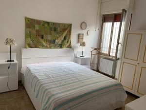 a bedroom with a bed with a striped blanket on it at Villa Margherita in Lecce