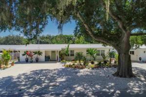 un edificio con un grande albero di fronte di Gorgeous Private Home with Heated Pool a Sarasota