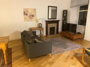 a living room with a couch and a fireplace at St Margaret's Loch Apartment in Edinburgh