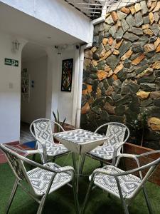 a table and four chairs in front of a stone wall at Hotel Casa Cielo Cartagena in Cartagena de Indias