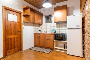 a kitchen with wooden cabinets and a white refrigerator at Arachova's Experience Guesthouse in Arachova