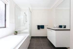 a white bathroom with a tub and a sink at Cape Retreat in Cape Schanck +18 photos