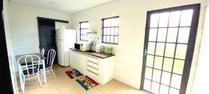 een kleine keuken met een witte koelkast en een tafel bij Casa de Campo Acolhedora e Confortável in Ribeirão Preto