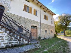 a brick building with a staircase next to a door at Gli ulivi Gualdo Tadino Uniquement de samedi à samedi Lits pour 10 personnes in Pieve di Compresseto