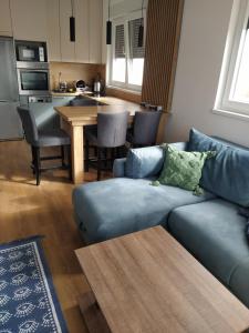 Una sala de estar con un sofá azul y una mesa. en Centar Sveta, en Zlatibor