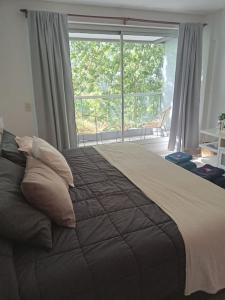 a bedroom with a large bed with a large window at Be Happy Studio Palermo Soho in Buenos Aires