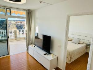 a bedroom with a bed and a flat screen tv at AMADORES BEACH VIEW APARTMENT in Amadores