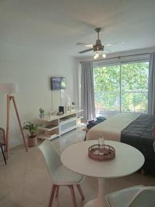 ein Wohnzimmer mit einem Bett, einem Tisch und Stühlen in der Unterkunft Be Happy Studio Palermo Soho in Buenos Aires