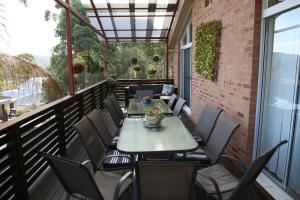 a patio with a table and chairs on a balcony at A Holiday Home for Every Season in Bateau Bay