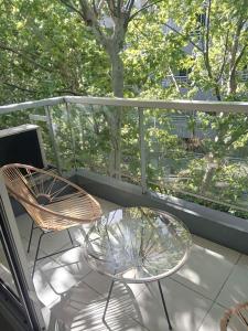 a balcony with a glass table and two chairs at Be Happy Studio Palermo Soho in Buenos Aires
