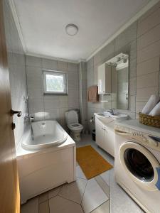 a bathroom with a sink and a washing machine at Kamenice soba L in Jajce