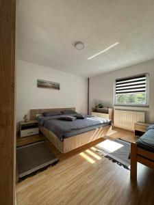 sypialnia z dużym łóżkiem i oknem w obiekcie Kamenice soba L w mieście Jajce