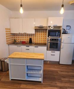 a kitchen with white cabinets and a wooden counter top at Appartement La Défense in Puteaux