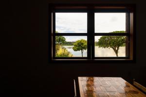 a window in a room with a view of a lake at Pousada Wafeh Pampulha Suítes in Belo Horizonte
