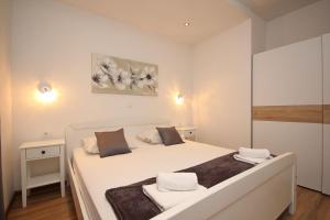 a bedroom with a white bed with two pillows at Apartmani Šulenta in Tučepi