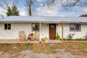Cette petite maison blanche dispose d'une terrasse en bois. dans l'établissement Charming Country Cottage in Goodspring!, à Pulaski