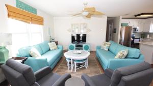 a living room with blue couches and a table at Oceanside, 5 BRs, Hot Tub, Rec Room, Close to Shopping, KH221, Shoebies Hangout in Kitty Hawk