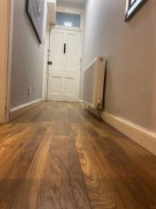 pusty pokój z drzwiami i drewnianą podłogą w obiekcie St Margaret's Loch Apartment w Edynburgu