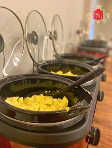 a stove with three pans of food on it at Hotel central campo grande in Campo Grande