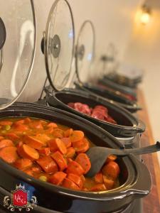un grupo de sartenes de alimentos sentados en una estufa en Hotel central campo grande, en Campo Grande