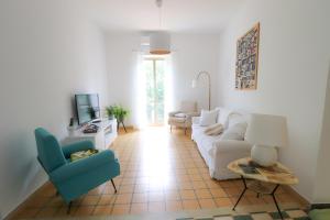 salon z białą kanapą i niebieskim krzesłem w obiekcie Home Sweet Home w mieście Vignanello
