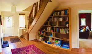 een woonkamer met een boekenplank gevuld met boeken bij Hector's House in Aviemore
