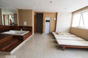 a large room with several beds and a mirror at Flat Luxo Jardim Goiás in Goiânia