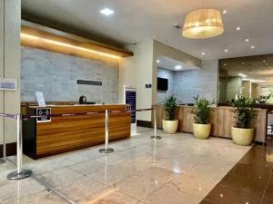a lobby with a reception desk and potted plants at Flat Luxo Jardim Goiás in Goiânia