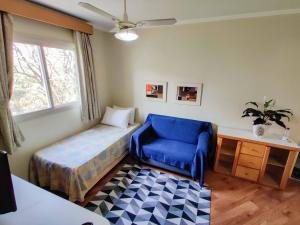 a bedroom with a bed and a chair and a window at Residencial Bella Vista Suites in Sao Paulo