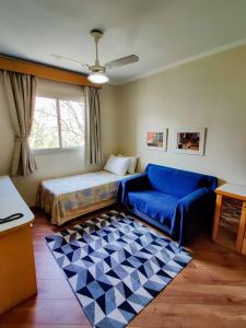 salon z łóżkiem i niebieską kanapą w obiekcie Residencial Bella Vista Suites w São Paulo