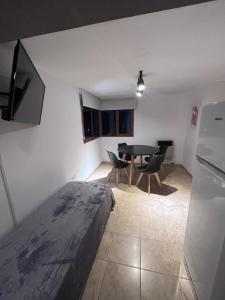 a bedroom with a bed and a table and chairs at Departamento cerca del centro - Carhue in Villa Carlos Paz