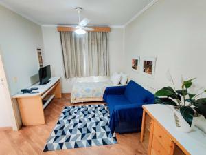 sala de estar con sofá azul y TV en Residencial Bella Vista Suites en São Paulo